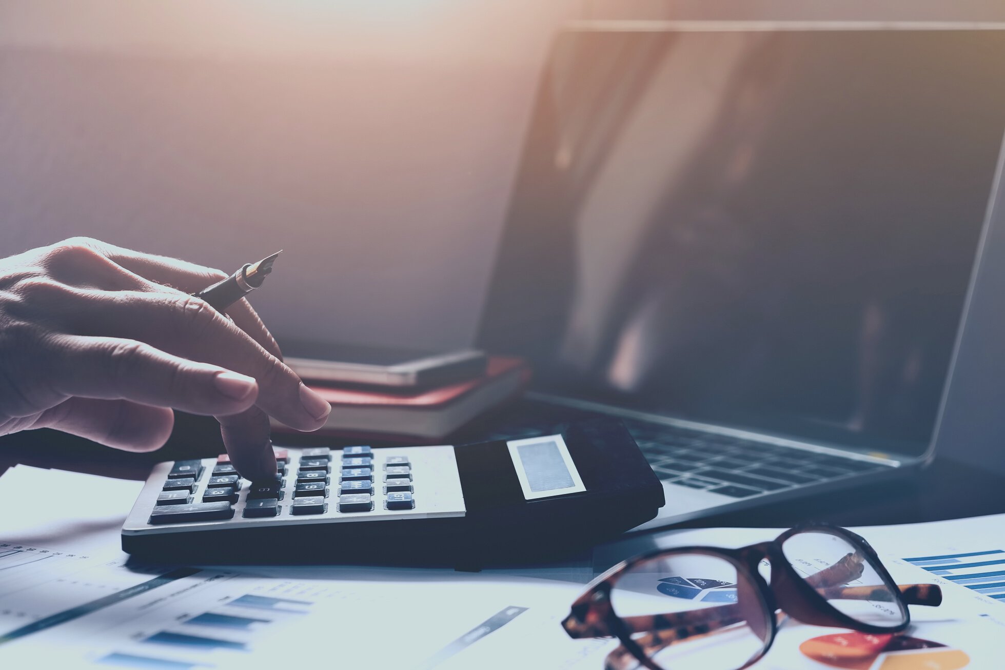 Business accounting, Business man using calculator with computer laptop, budget and loan paper in office.